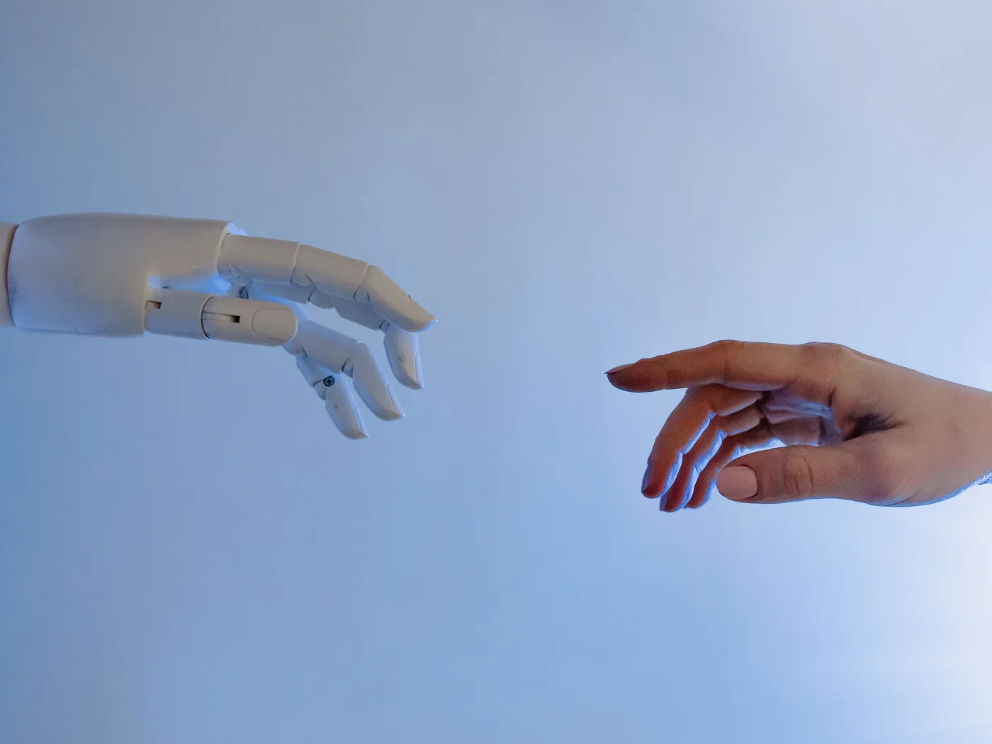 Human and robotic hands approaching one another